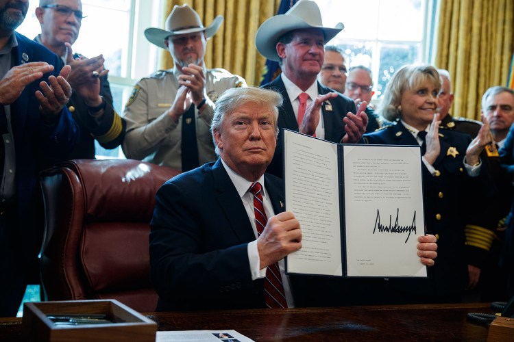 President Trump holds up his veto overruling Congress to protect his emergency declaration for border wall funding on March 15 in Washington. Congress likely doesn't have enough votes to override the veto.