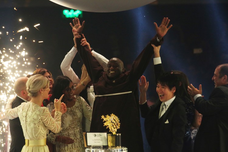 Kenyan teacher Peter Tabichi, center, reacts after winning the $1 million Global Teacher Prize in Dubai, United Arab Emirates on Sunday

