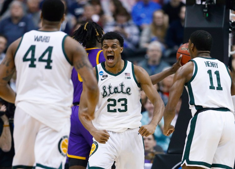 Michigan State's Xavier Tillman celebrates a basket with teammates Nick Ward, left, and Aaron Henry during an 80-63 win over LSU in an East Regional semifinal Friday night.