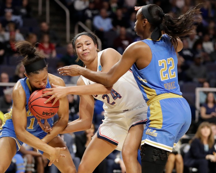 UCLA's Lajahna Drummer, left, gets hit with the basketball as she tries to steal the ball from UConn's Napheesa Collier with UCLA guard Kennedy Burke defending in the first half Friday night at Albany, N.Y.
Associated Press/Kathy Willens