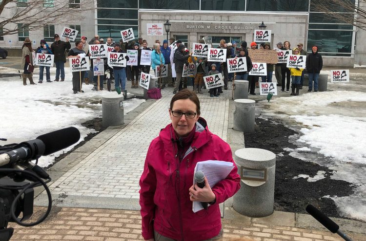 Sandra Howard, director of the Say NO to NECEC group opposed to Central Maine Power’s proposed transmission line, speaks to reporters as protesters rally outside the State House on Friday. 