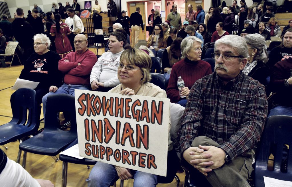 Gloria and Ken Gordon, of Skowhegan, hold a sign in favor of keeping the Indian mascot during a School Administrative District 54 school board meeting in January. 