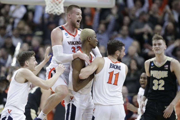 Virginia's Jack Salt (33) celebrates with teammates Mamadi Diakite and Ty Jerome (11) after Diakite hit a shot to send the South Regional final into overtime on Saturday in Louisvile, Kentucky. Virginia won 80-75 to reach the Final Four for the first time since 1984.