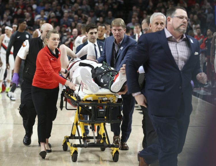 Portland Trail Blazers center Jusuf Nurkic, center, was injured and left the court on a stretcher as the Blazers beat the Brooklyn Nets in double overtime, 148-144, Monday night.