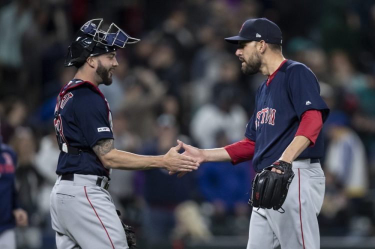 Red Sox pitcher Matt Barnes, right, shakes hands with catcher Blake Swihart after earning his first save of the season in Boston's 7-6 victory over the Mariners on Friday in Seattle. 