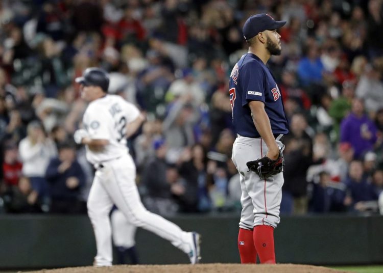 Boston Red Sox starting pitcher Eduardo Rodriguez, right, looks away as Seattle Mariners' Jay Bruce rounds the bases after his three-run home run in the fifth inning  Saturday night in Seattle. 