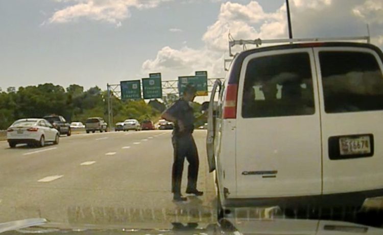 In this photo taken from the video dashboard camera of Maine State Police Trooper Robert Burke III, the trooper talks to the driver of a van carrying about a dozen immigrants on Interstate 295 in Portland on Sept. 9. Burke eventually contacted U.S. Immigration and Customs Enforcement.