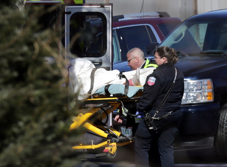 Emergency medical technicians carry a person on a stretcher into an ambulance outside the Quality Inn on Thursday in Manchester, N.H. 