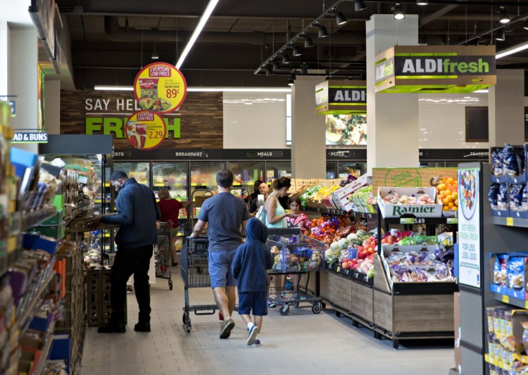 Shoppers walk through the fresh produce department at an Aldi food market in Chicago.