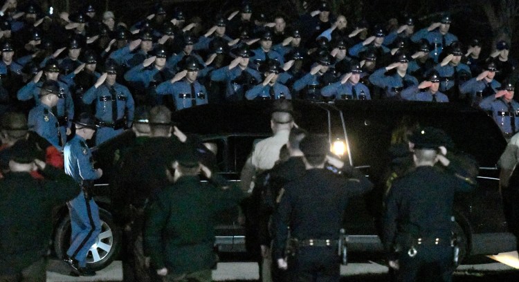 Troopers salute Wednesday evening as the body of Maine State Police Detective Benjamin Campbell is escorted to the Medical Examiner's Office in Augusta. Campbell was killed Wednesday morning in a freak accident on Interstate 95 in Hampden.
