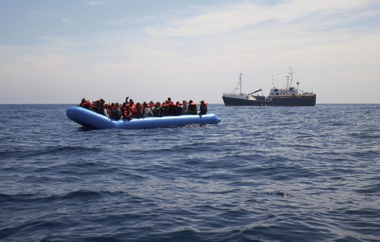 Migrants on a rubber dinghy are approached by the Sea-Eye rescue ship in the waters off Libya on Wednesday.