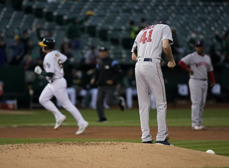 Boston Red Sox pitcher Chris Sale (41) stands on the mound after allowing a solo home run to Oakland Athletics' Matt Chapman, left, during the first inning of a baseball game in Oakland, Calif. 