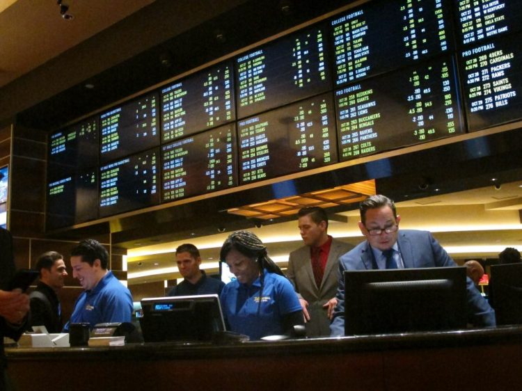 FILE - In this Oct. 25, 2018, file photo, employees prepare to take bets moments before the new sports book at the Tropicana casino in Atlantic City, N.J., opened. Most of the states that moved quickly to legalize sports betting after a Supreme Court decision last year are still waiting for the expected payoff. Only New Jersey and Delaware saw the tax revenue to their state budgets meet projections. (AP Photo/Wayne Parry, File)
