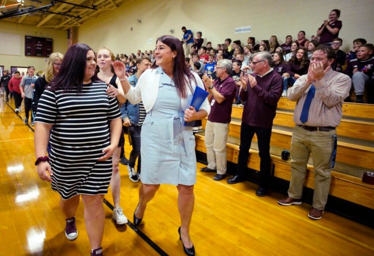Heather Whitaker, an alternative education teacher at Gorham Middle School, walks into the school’s gynmasium with Sydnie Adams, left, and other students at the start of a ceremony where she was named the 2020 Maine Teacher of the Year on Thursday. 