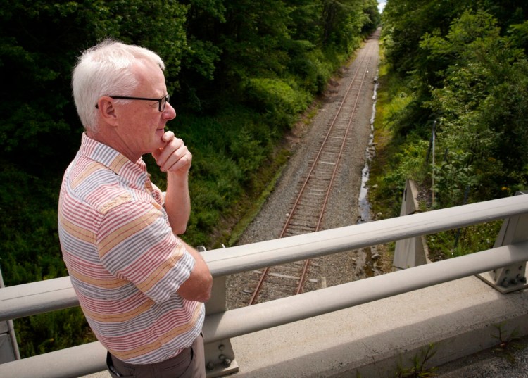 Dick Woodbury of the Casco Bay Trail Alliance stands on the Route 231 bridge over the St. Lawrence and Atlantic Railroad line in New Gloucester on Aug. 2. The alliance is proposing a 25-mile rail-trail corridor along the track route from Auburn to Portland, but Woodbury learned this week that the state is again looking to extend its abandonment agreement with the railroad, which last ran freight on the state-owned line in 2015.