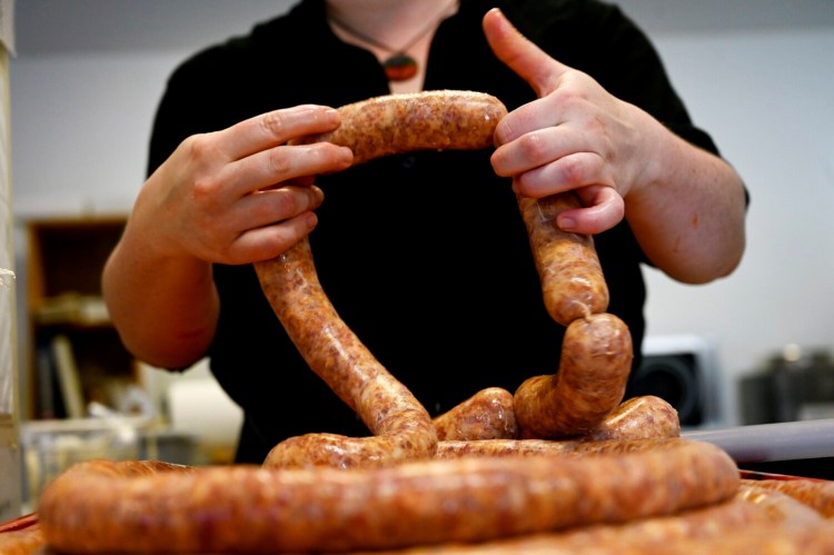 Alex Chilton, Butcher Manager at Solo Cucina Market in South Portland, forms sausages. The market, and several others in Maine, sell sausages in imaginative flavors. 