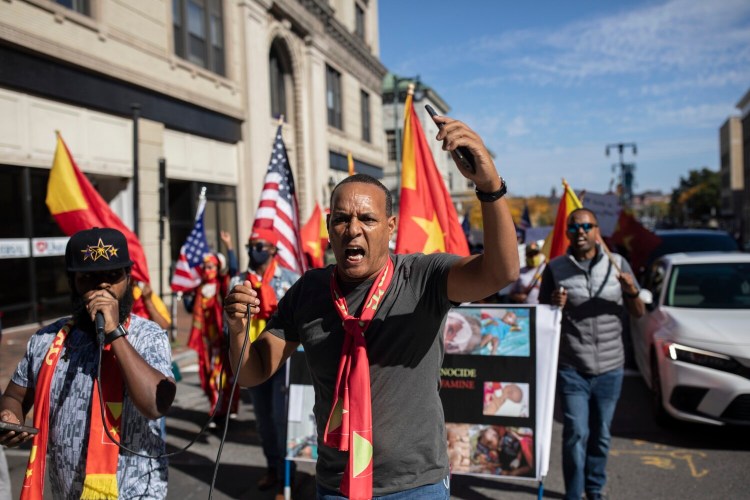 Yekuno Mesfin, center, leads chants against the Ethiopian government during a protest in Portland on Wednesday to bring attention to the humanitarian crisis caused by the war in the country's Tigray region. Mesfin was among the members of the Tigrayan community from the Boston area who came to Portland for the protest organized by Hagos Tsadik of Cape Elizabeth.