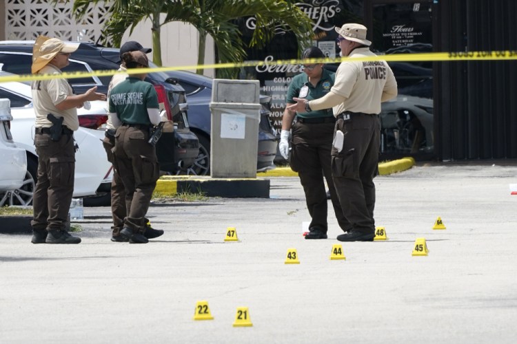 Law enforcement officials work the scene of a shooting outside a banquet hall near Hialeah, Fla., in May. The Florida governor has offered to pay $5,000 to police officers from other states who refuse to get the COVID-19 vaccine if they accept a law enforcement job in Florida. 