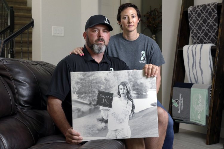 David and Wendy Mills, parents of Kailee Mills who was killed four years ago in an automobile accident when riding in the back seat without a seat belt, hold a photo of their daughter at their home in Spring, Texas on Oct. 12. The teenager was riding in the back seat of a car to a Halloween party just a mile from her house when she unfastened her seat belt to slide next to her friend and take a selfie. Moments later, the driver veered off the road and the car flipped, ejecting her. 

