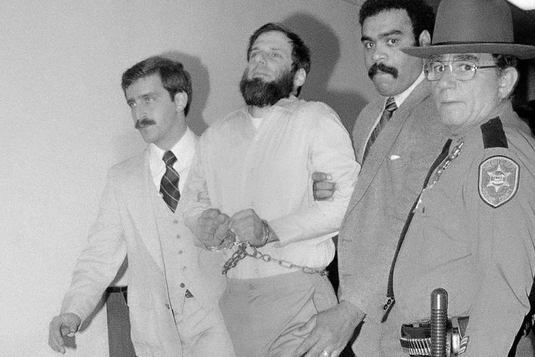 Law enforcement officials escort a handcuffed David Gilbert from Rockland County Court in New City, N.Y., in 1981. 

