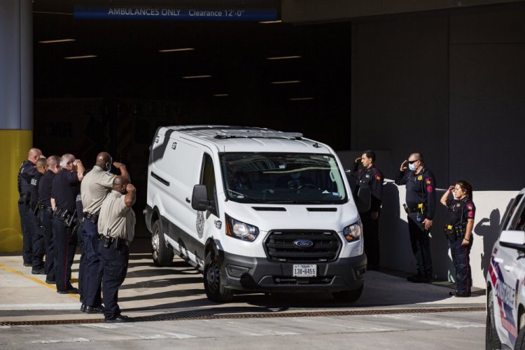 A Harris County Medical Examiner van exits the Memorial Hermann Hospital transporting a Harris County Pct. 4 deputy who was shot and killed to the Harris County Institute of Forensic Sciences, Saturday in Houston.