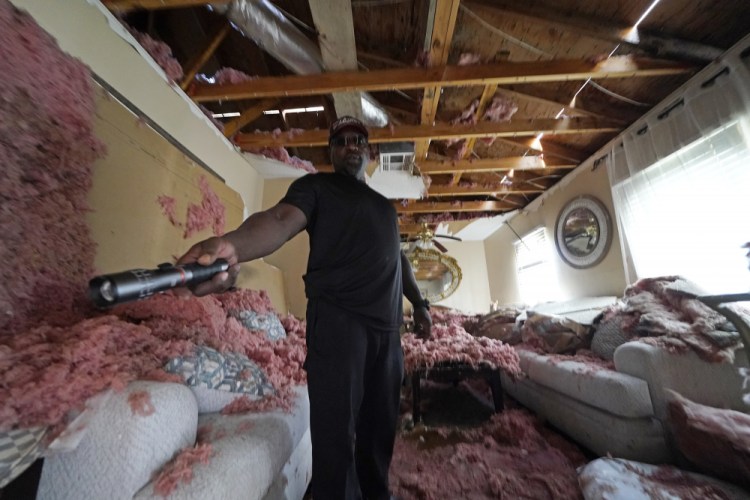 Michael Lathers shows the insulation and collapsed ceiling in his flooded home Sept. 7, in the aftermath of Hurricane Ida in LaPlace, La. 

