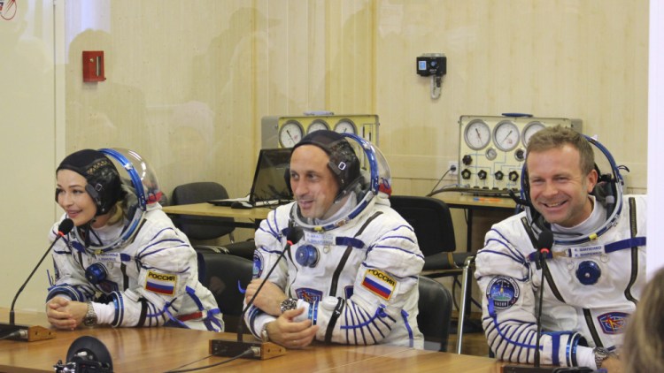 Actress Yulia Peresild, left, film director Klim Shipenko, right, and cosmonaut Anton Shkaplerov speak with their relatives through a safety glass before the launch at the Baikonur Cosmodrome in Kazakhstan on Tuesday.

