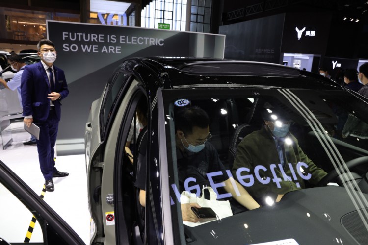 A promoter stands near the all-electric Volvo XC40 during the Shanghai Auto Show in Shangha in April. Global automakers are stepping up the pace when it comes to building factories to prepare for what many believe will be a fast-moving transition from internal combustion engines to electric vehicles.(AP Photo/Ng Han Guan, File)