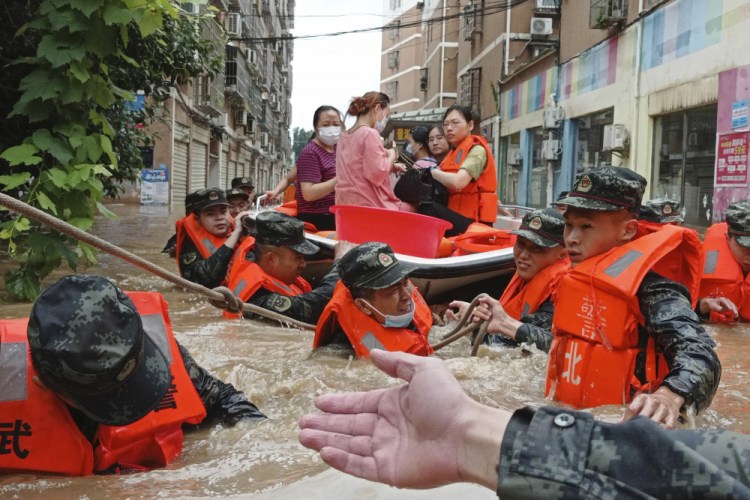 Paramilitary police work to evacuate people trapped in a flooded area Aug. 12 in Suizhou, China. 

