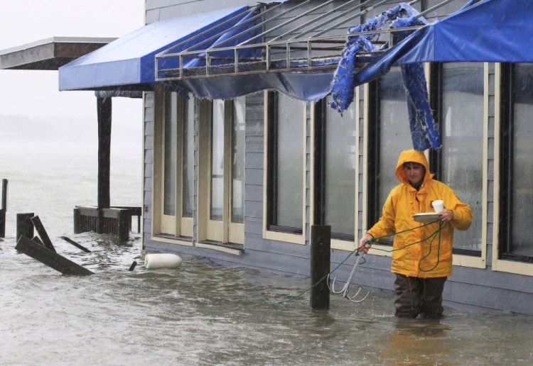 A worker retrieves a grappling hook on the dock next to Bubba's restaurant on the water in Virginia Beach, Va., in October 2012. Voters in Virginia Beach will consider whether to vote for a $500 million bond on election day that would be used for protection against flooding from rising seas and intensifying hurricanes.