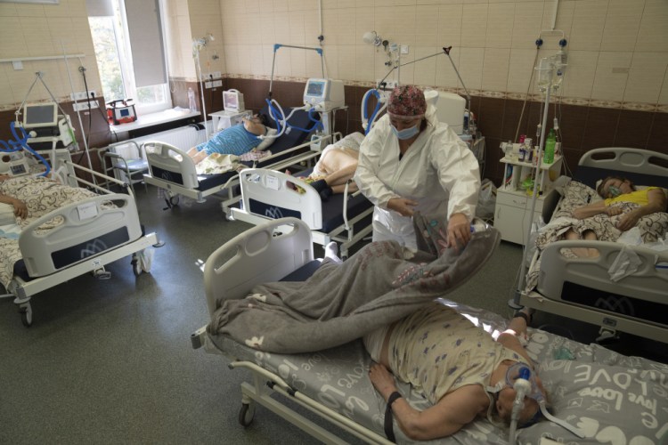 A nurse covers a patient who has COVID-19 with a blanket at the ICU at the regional hospital in Kharkiv, Ukraine, on Oct. 15. Ukraine is suffering through a surge in coronavirus infections, along with other parts of Eastern Europe and Russia. While vaccines are plentiful, there is a widespread reluctance to get them in many countries. 