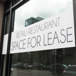 A banner in a window advertising commercial retail and restaurant space for lease