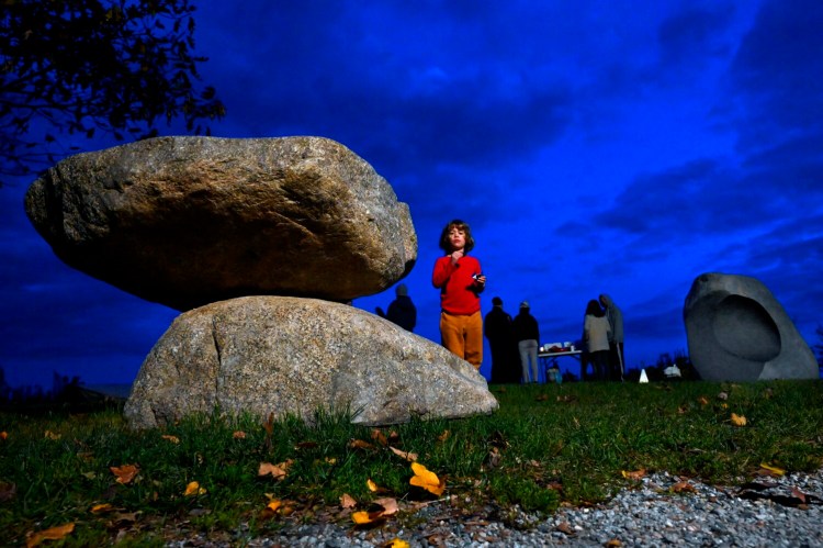 Jago Reinharz-Trainor, 5, of Portland looks over the piece "Gathering Stones," by the artist Jesse Salisbury while enjoying a snack during a reception Thursday at Fish Point on Portland's Eastern Promenade.