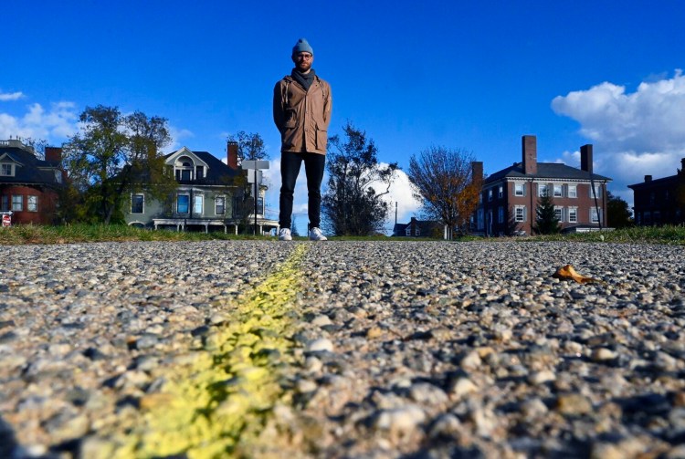 C.J. Opperthhauser, one of the participants in a public art project in Portland, stands on his path Wednesday, along a sidewalk on the Western Prom.