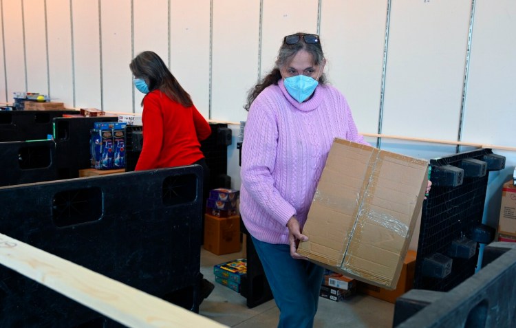 Kathleen Meade, director of the Portland Press Herald Toy Fund, moves a box filled with toys for the Toy Fund at the Freeport warehouse Tuesday. 