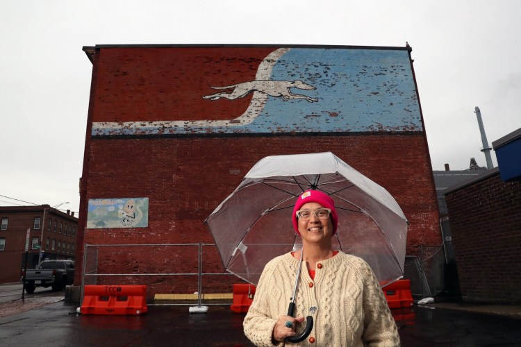 Lisa Willey, of Casco, outside the Greyhound Bus terminal on Congress Street in Portland Friday. Building owner MaineHealth said it plans to remove the mural to rebuild the structure's outer wall, which has been damaged by the elements.