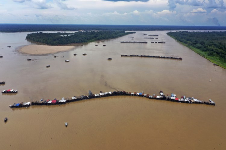 Dredging barges operated by illegal miners converge on the Madeira River, a tributary of the Amazon River, searching for gold, on Thursday.  (AP Photo/Edmar Barros)