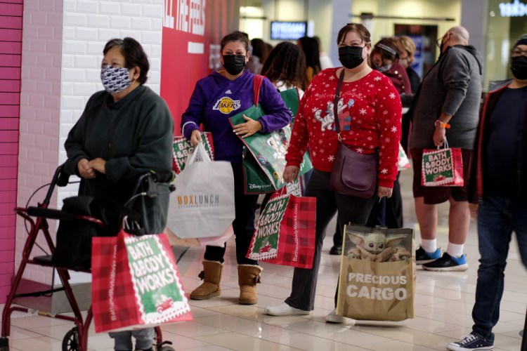 Black Friday shoppers wearing face masks wait in line to enter a store at the Glendale Galleria in Glendale, Calif., Friday, Nov. 27, 2020.