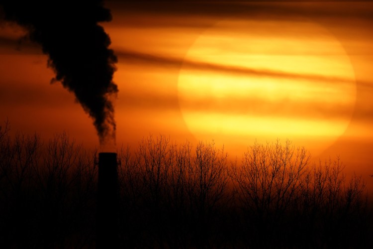 Emissions from a coal-fired power plant are silhouetted against the setting sun Feb. 1 in Kansas City, Mo. 

