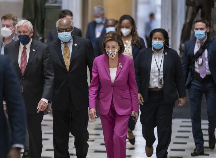 Speaker of the House Nancy Pelosi, D-Calif., center, joined from left by House Majority Leader Steny Hoyer, D-Md., and House Majority Whip James Clyburn, D-S.C., walks to update reporters after delays in the vote to advance President Biden's domestic policy package, at the Capitol in Washington on Friday. 

