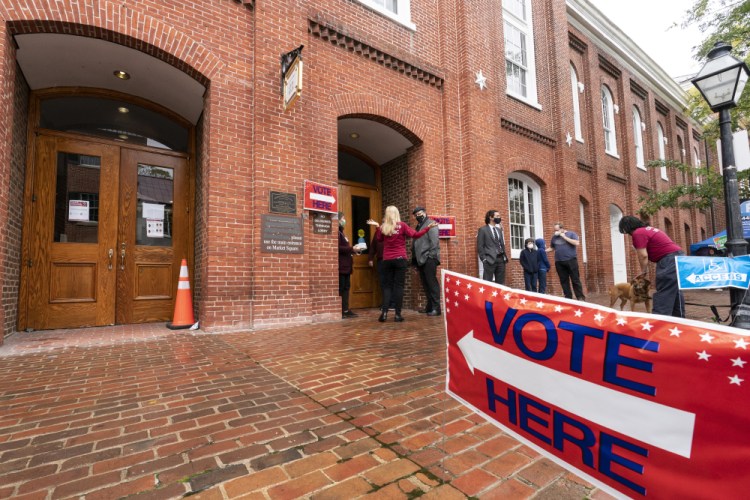 Voters arrive to cast the their ballots on Election Day at City Hall on Tuesday, in Alexandria, Va. Millions of Americans now believe in conspiracy theories trumpeting rampant electoral fraud. 


