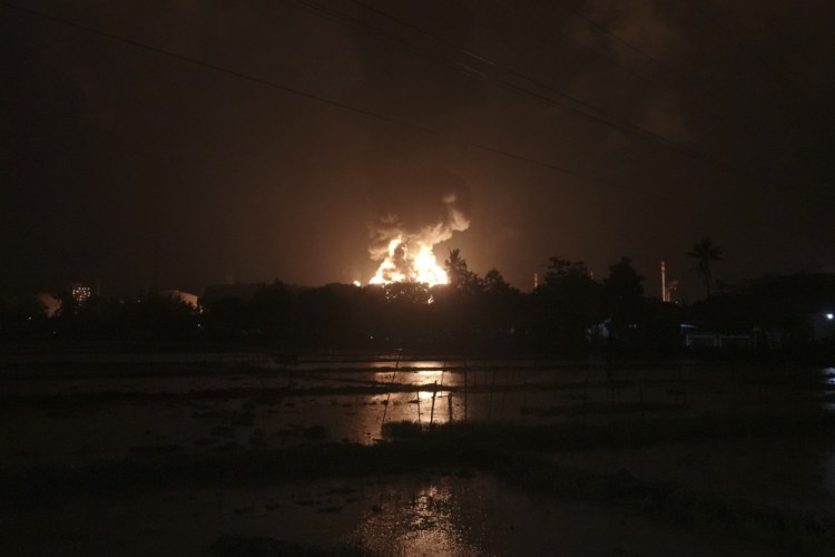The sky glows from the fire that razes through an oil refinery owned by the national oil company Pertamina, in Cilacap, Central Java, Indonesia, on Saturday.
