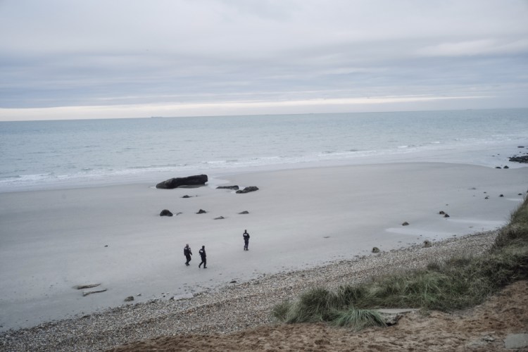 French police officers patrol the beach as they  search for migrants in Wimereux, northern France, on Wednesday. A boat capsized off Calais in the English Channel as a group of migrants tried to cross from France to Britain, authorities said. 