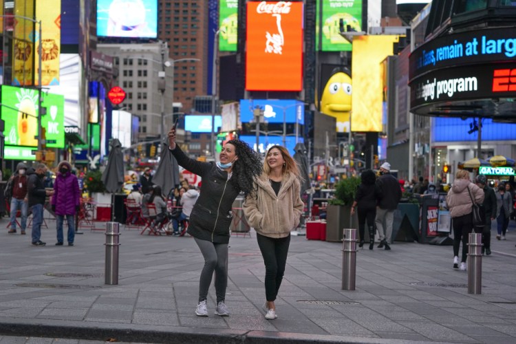 Pedestrians pose for selfies in Times Square last week in New York.