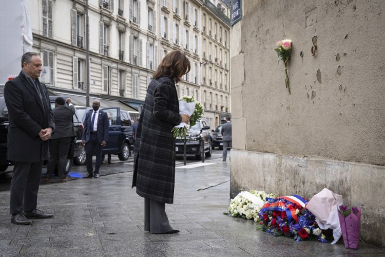 Vice President Kamala Harris lays flowers to honor the victims of the attack on Paris at the Carillon Café on Saturday.   
