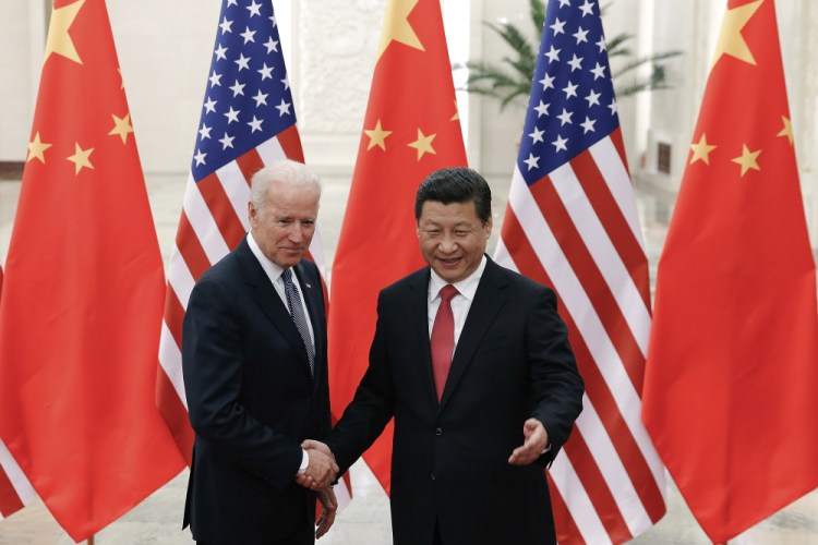 Chinese President Xi Jinping, right, shakes hands with Vice President Joe Biden as they pose for photos at the Great Hall of the People in Beijing, Dec. 4, 2013. 