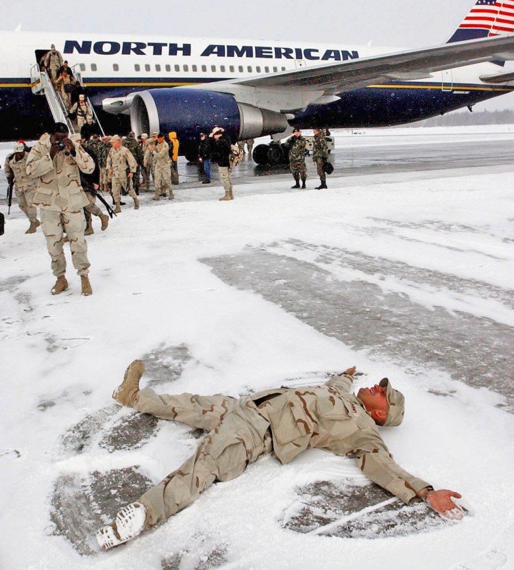 SPC. Norman Voter of Scarborough and a member of the Maine Army National Guard 133 Engineer Battalion drops down on the snow covered tarmac at Ft. Drum N.Y. on Feb 25, 2005 and does a snow angel, ending a year long deployment in Mosul, Iraq.