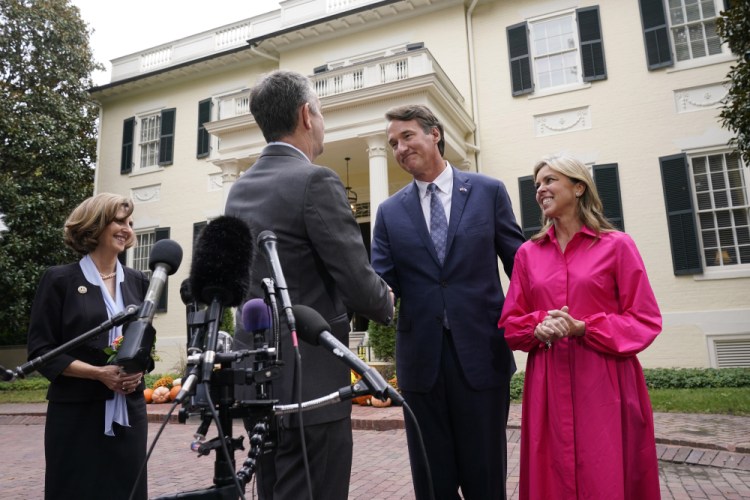 Virginia Gov. Ralph Northam, second from left, shakes the hand of Gov. Elect Glenn Youngkin, second from right, as Suzanne Youngkin, right, and Pam Northam look on after a transition meeting outside the Governors Mansion at the Capitol in Richmond, Va., Thursday, Nov. 4. 