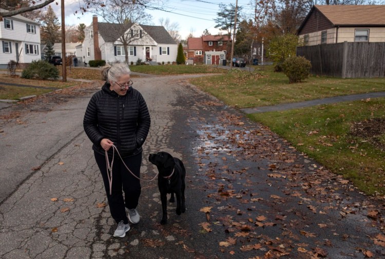 Alden Circle resident Christina Strubbe walks her dog in her Portland neighborhood. Capisic Brook has landed her home on an expanded floodplain map.