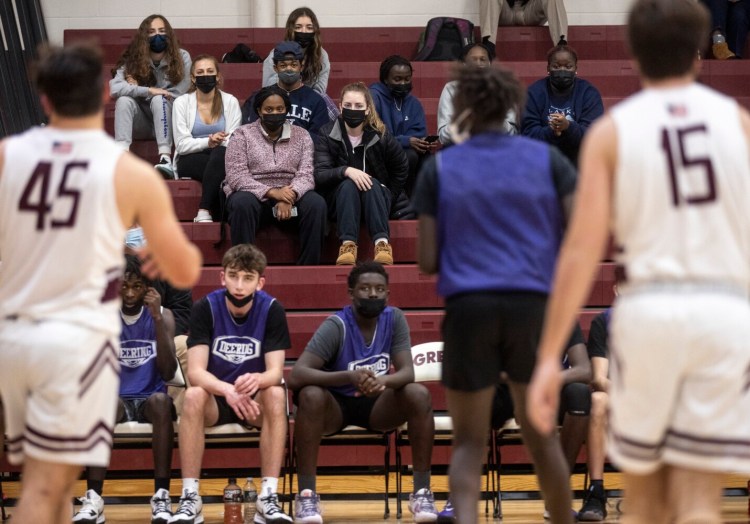 Deering High School students watch as their team plays in a scrimmage against Greely High School in Cumberland on Wednesday.